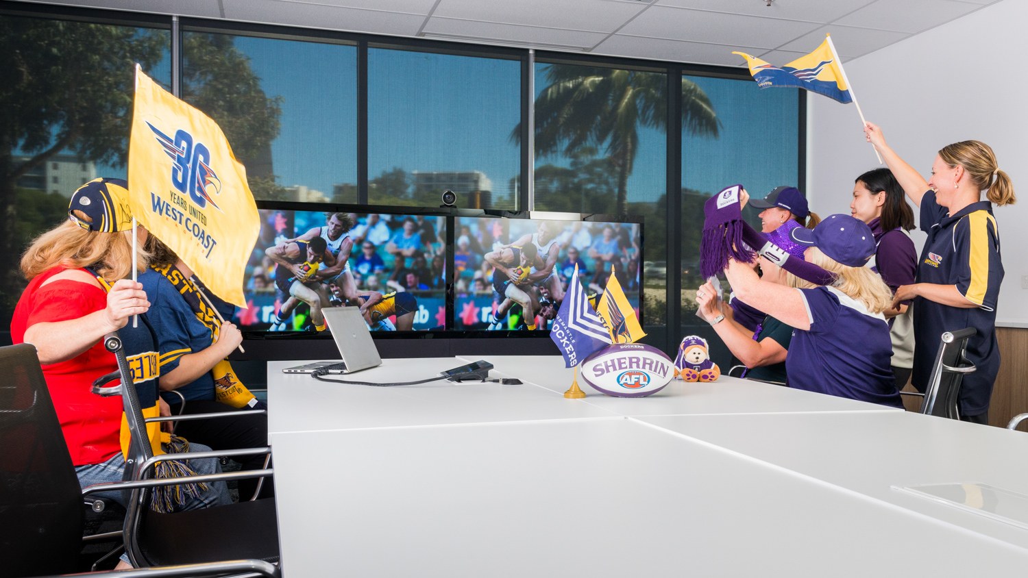 Beyond Bank colleagues with football scarves and flags in a meeting room