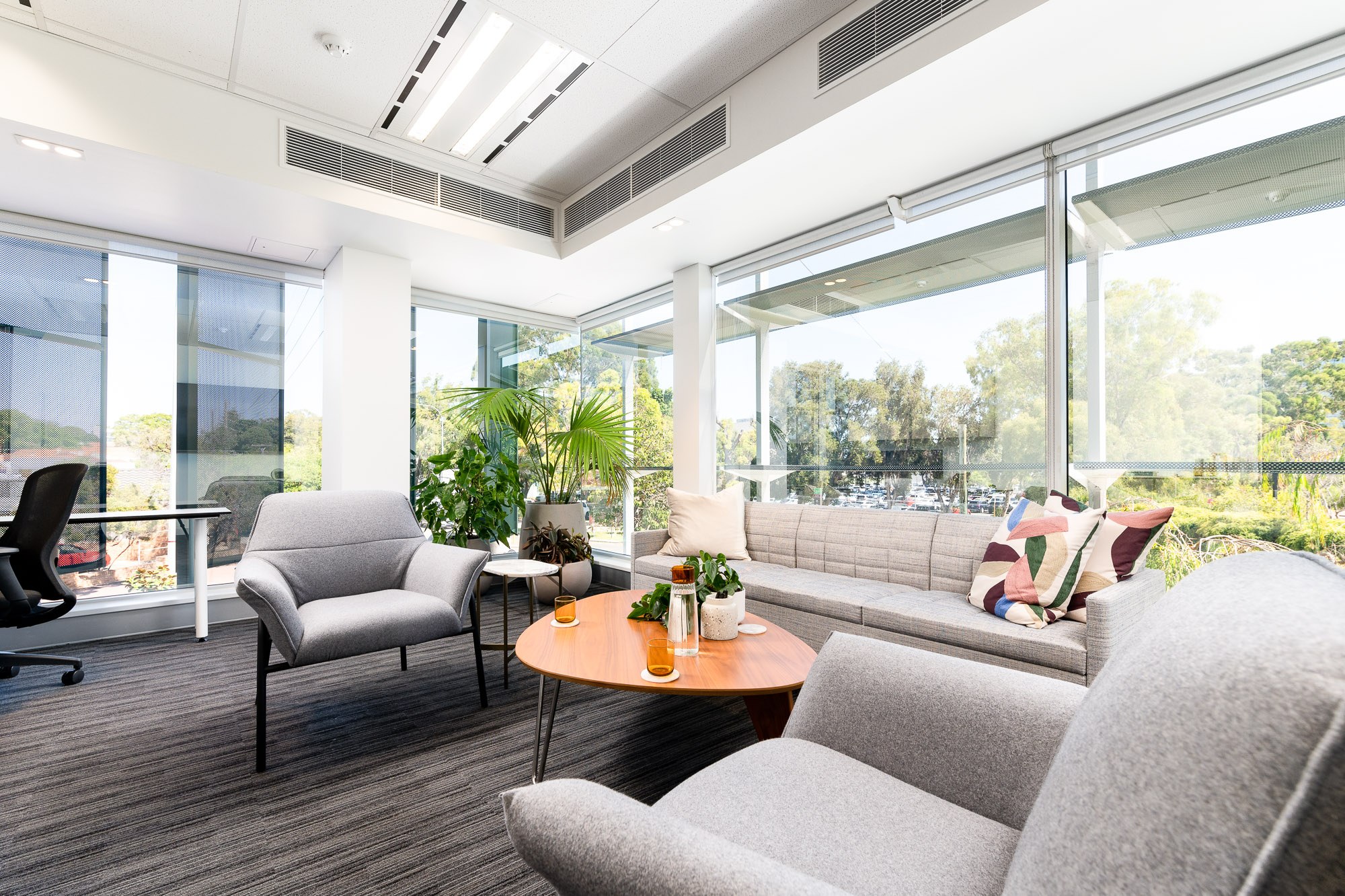 Bright office seating area with large windows and plants