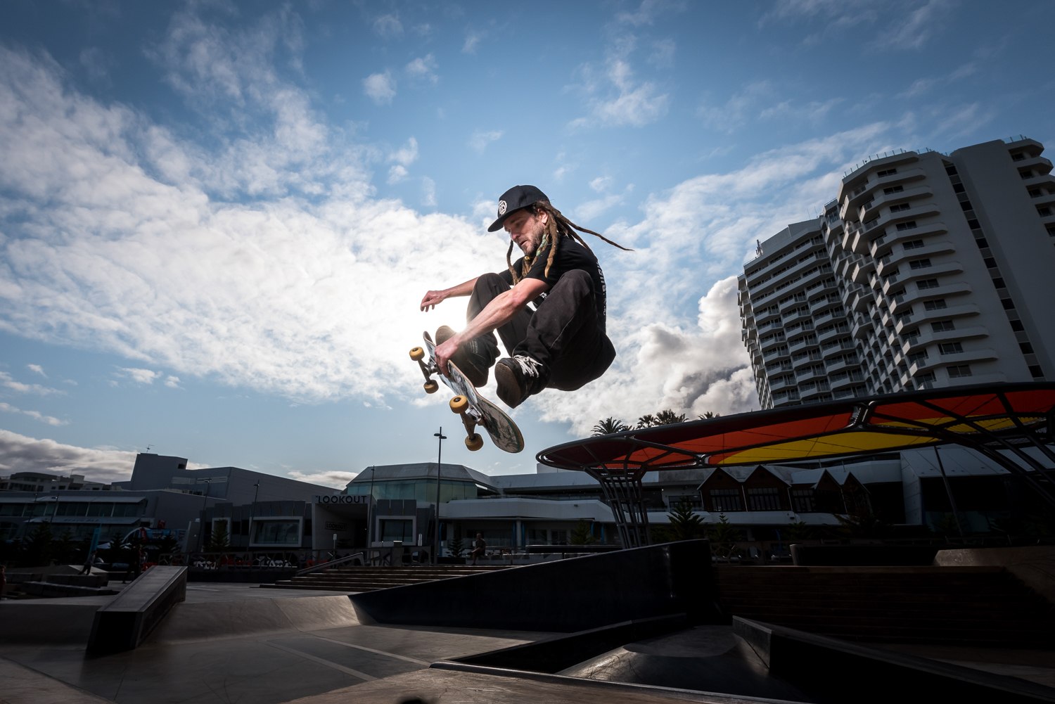 Skateboarder airborne at a coastal skate park