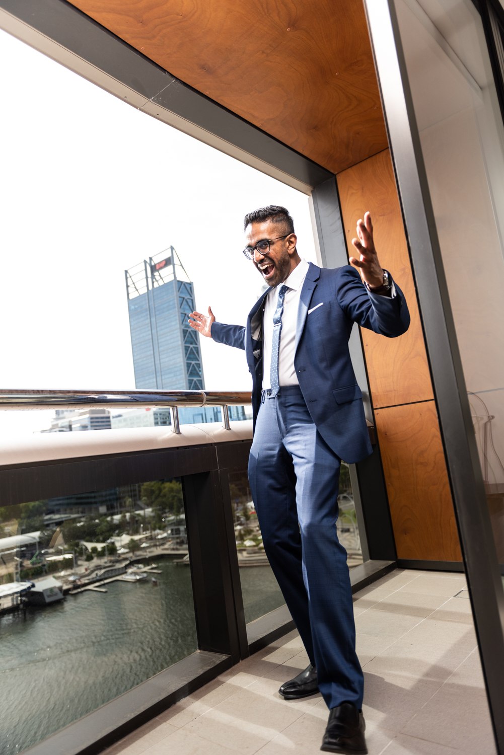 Full-length business portrait on a balcony overlooking the city