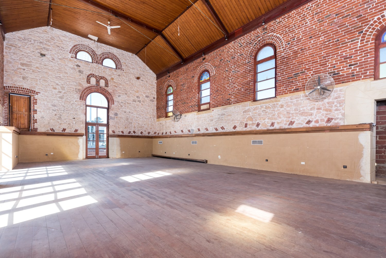 Character property interior with exposed brick, arched windows and timber ceiling in Fremantle