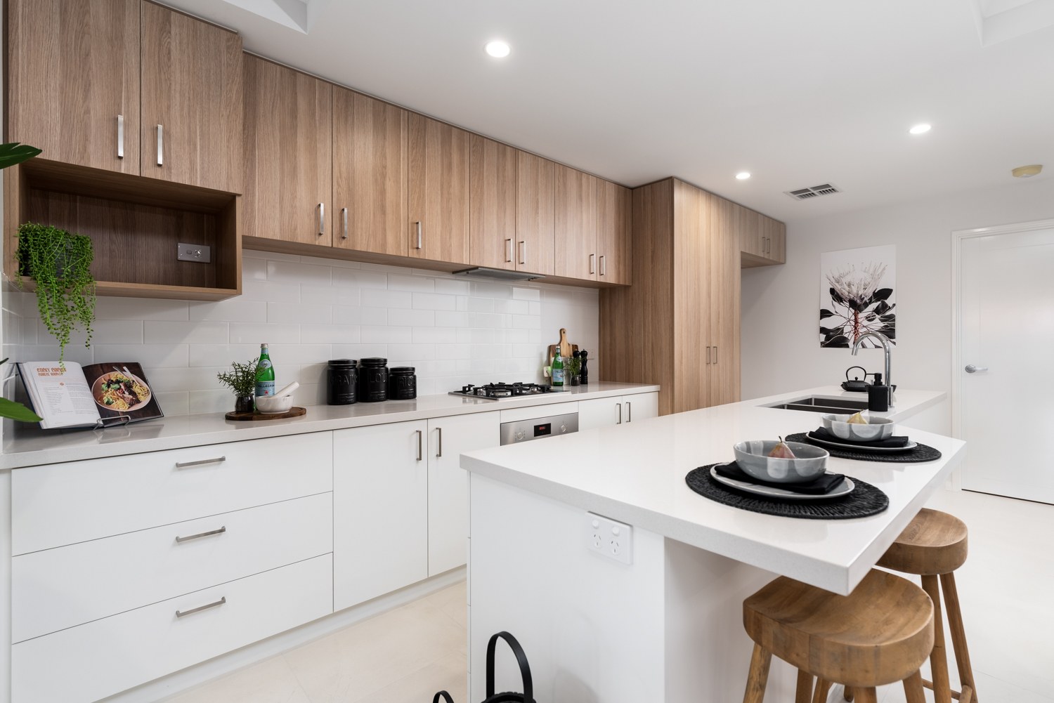 Kitchen with timber cabinetry and white benchtops in Yokine